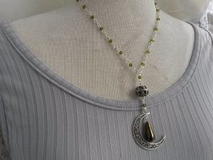 Halsband med snirklig måne pendel glaspärlor i kedjan